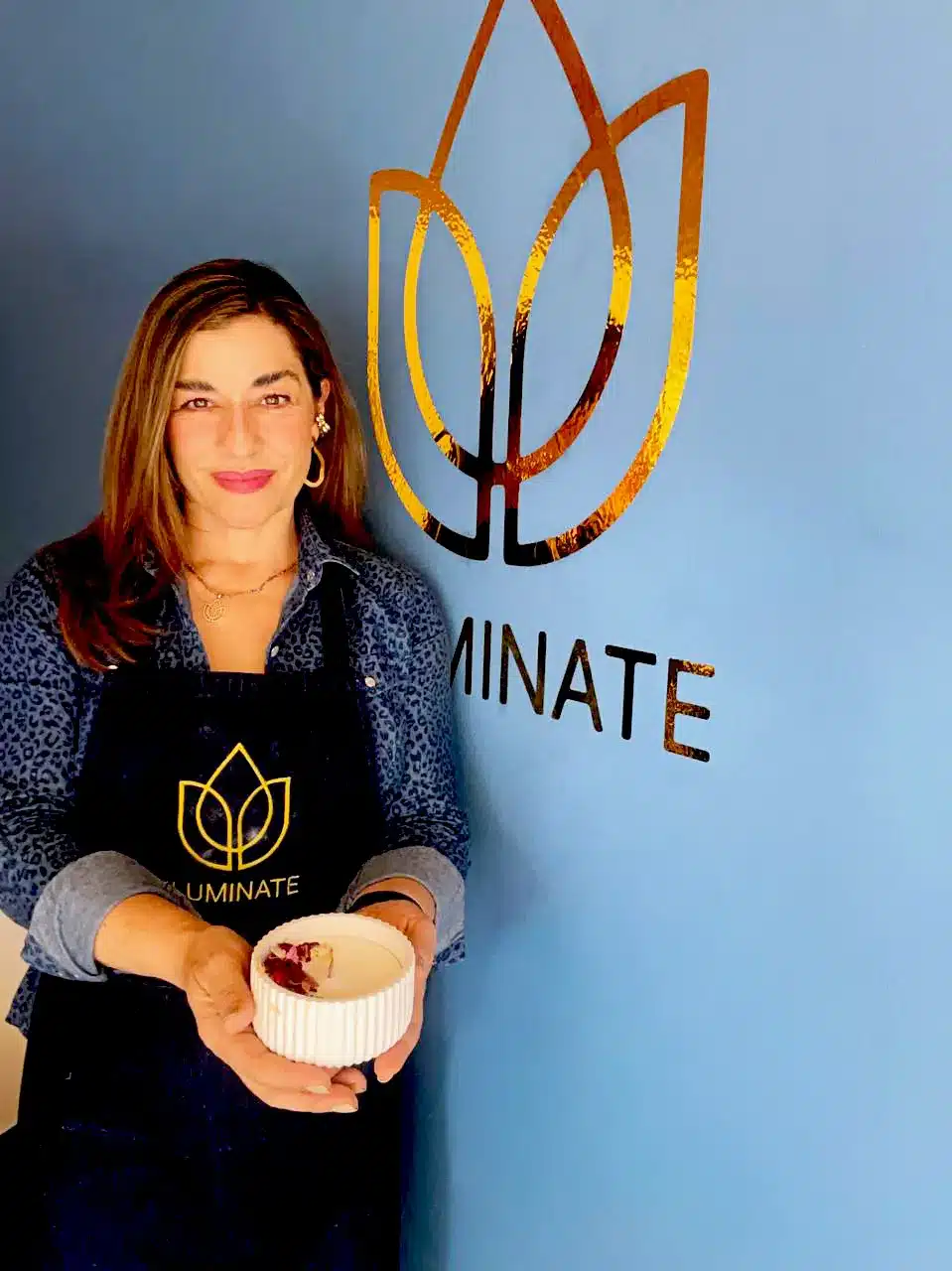 Grupo de mujeres y un niño sonrientes participando en un taller de velas artesanales Iluminate